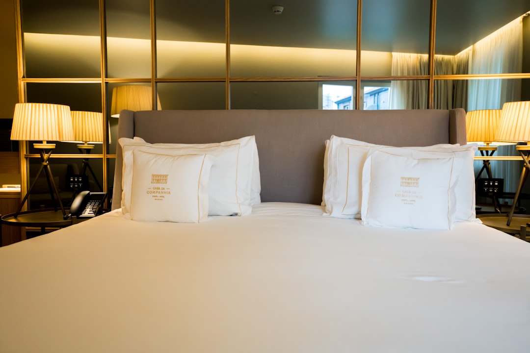 a-neatly-made-bed-with-white-pillows-and-lamps-sks0z89rl2w